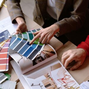 Interior designers discuss color swatches and design ideas at a table, planning a creative project.